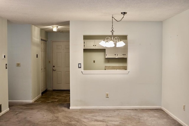 unfurnished dining area featuring a textured ceiling