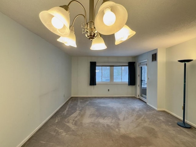 carpeted empty room with a textured ceiling