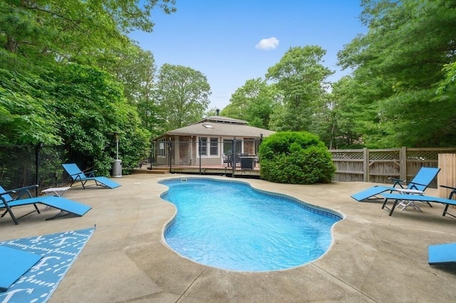 view of pool featuring a patio, a fenced backyard, a fenced in pool, and a wooden deck