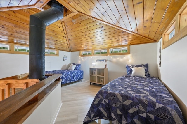 bedroom featuring a wood stove, hardwood / wood-style flooring, multiple windows, and wood ceiling