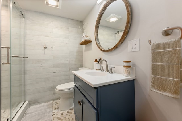 bathroom with toilet, a shower with door, and vanity