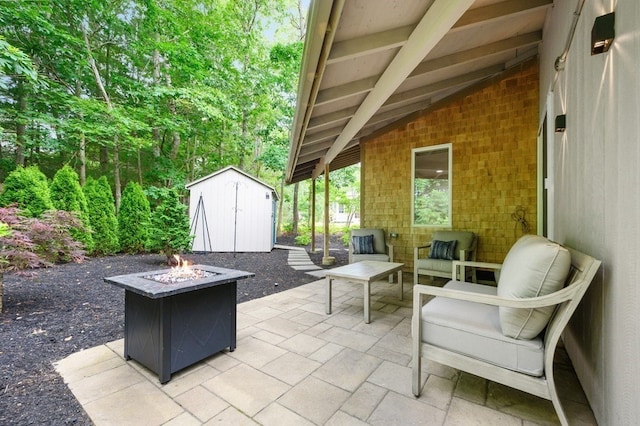 view of patio with an outdoor living space with a fire pit and a shed