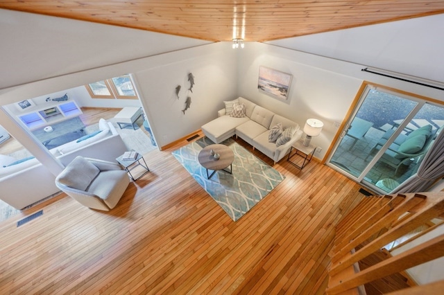 living room with vaulted ceiling, hardwood / wood-style floors, and wood ceiling