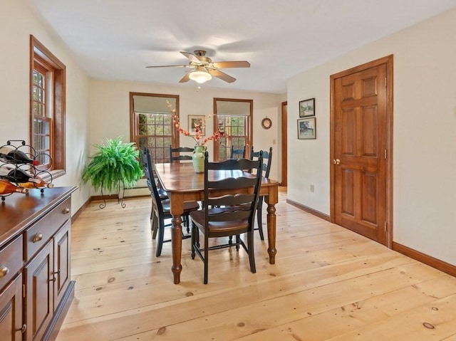 dining space with baseboards, ceiling fan, and light wood-style flooring