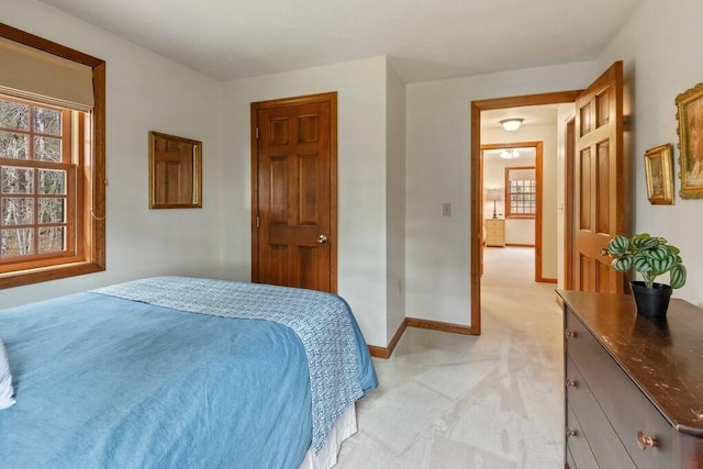 bedroom with baseboards and light colored carpet