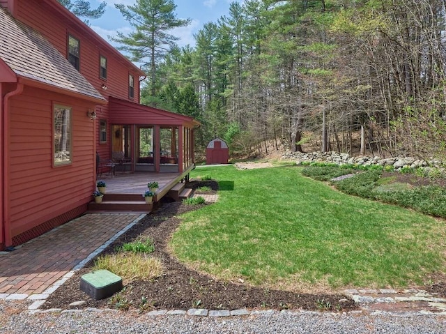 view of yard featuring a wooden deck, an outbuilding, and a shed