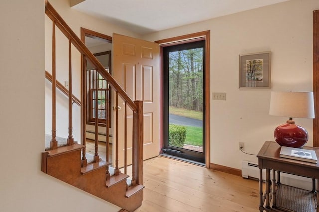 doorway with baseboards, light wood-style flooring, stairs, and baseboard heating