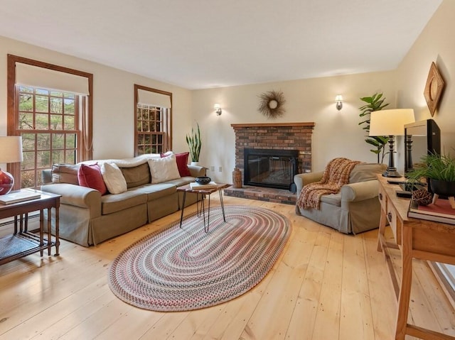living room with a brick fireplace and hardwood / wood-style floors