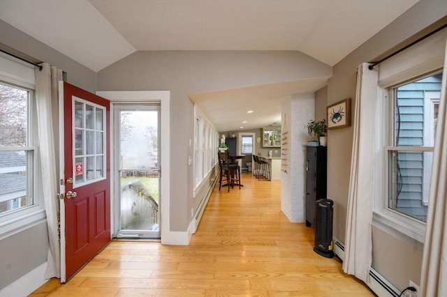 entrance foyer featuring a baseboard heating unit, light hardwood / wood-style floors, and lofted ceiling