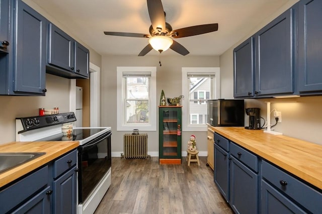 kitchen featuring radiator, blue cabinets, butcher block countertops, white electric stove, and wood-type flooring