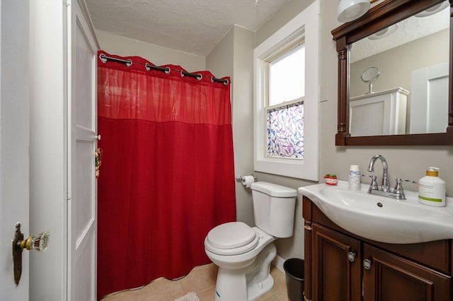 bathroom with tile patterned floors, vanity, a textured ceiling, and toilet