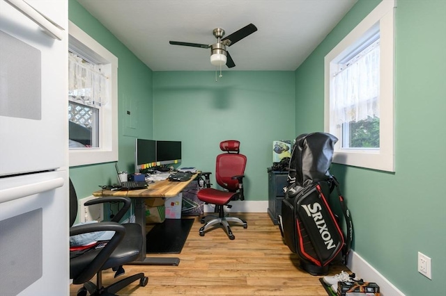 office with light hardwood / wood-style floors and ceiling fan