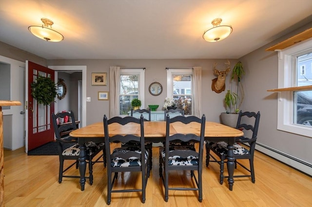 dining room featuring a baseboard radiator and light hardwood / wood-style floors