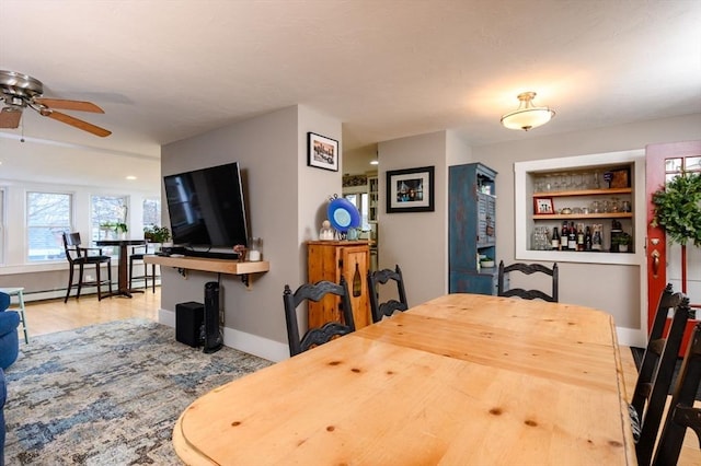 dining space featuring ceiling fan, built in features, and a baseboard radiator