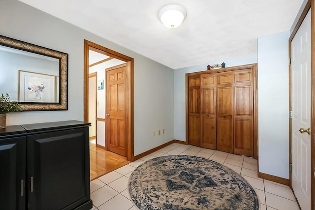 foyer featuring light tile patterned floors and baseboards