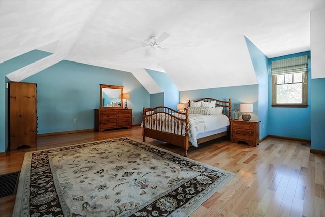 bedroom featuring a ceiling fan, baseboards, vaulted ceiling, and wood finished floors