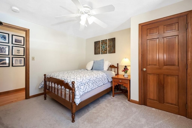 bedroom with light carpet, ceiling fan, and baseboards