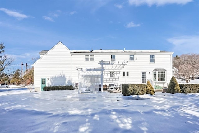 snow covered house featuring a pergola