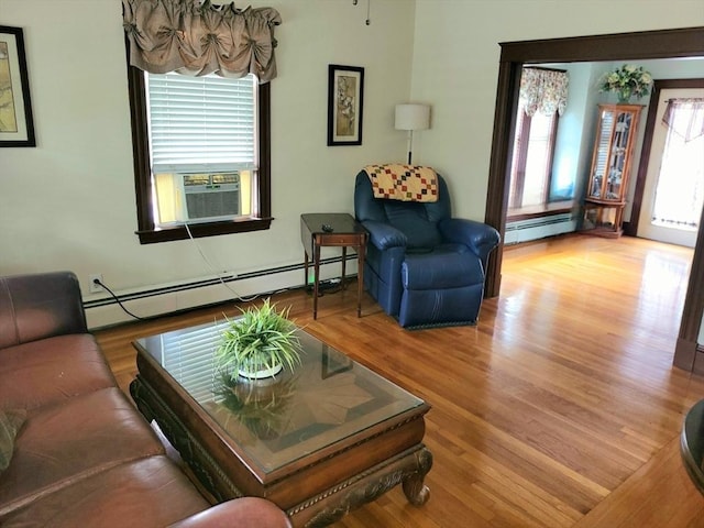 living room featuring wood-type flooring, baseboard heating, and cooling unit