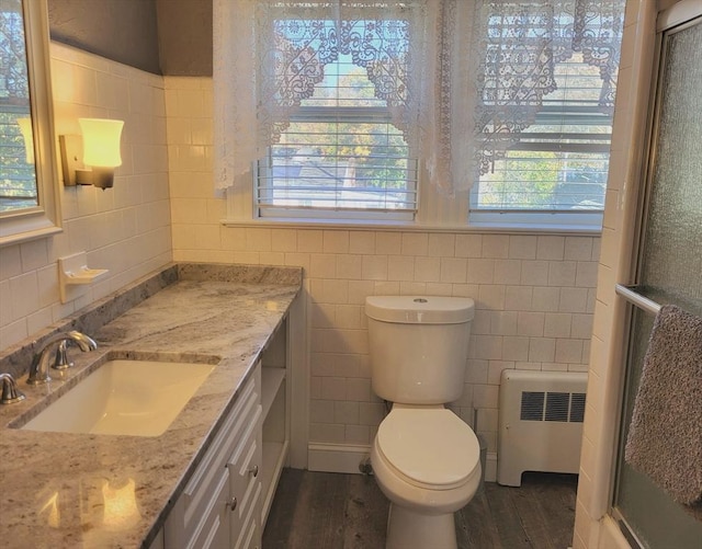 bathroom featuring vanity, toilet, wood-type flooring, and radiator