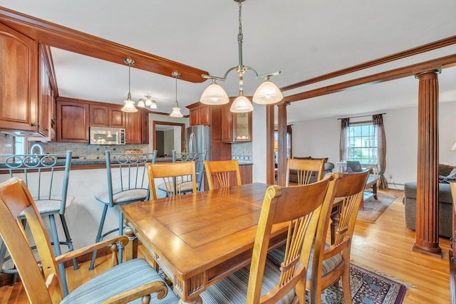 5 Upland St, Auburn, MA 01501 - dining space featuring decorative columns, light wood-style floors, and a baseboard radiator