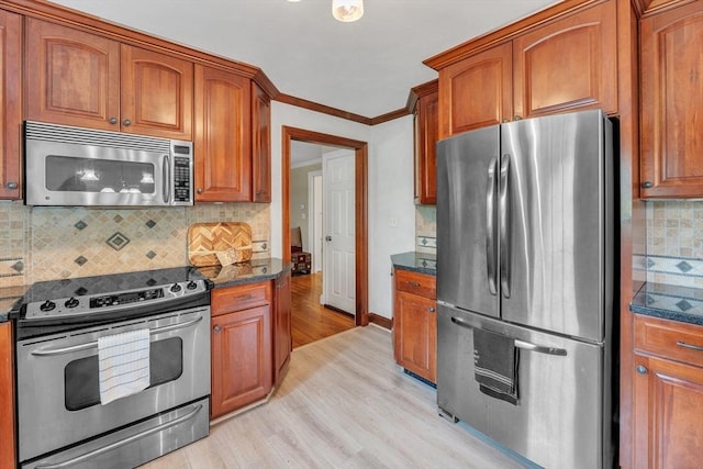 5 Upland St, Auburn, MA 01501 - kitchen featuring stainless steel appliances, light wood finished floors, tasteful backsplash, brown cabinets, and ornamental molding