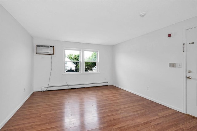 45 W 3rd St Unit 6, Lowell, MA 01850 - empty room with a baseboard heating unit, a wall unit AC, wood finished floors, and a smoke detector
