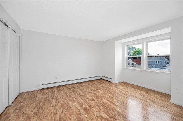 45 W 3rd St Unit 6, Lowell, MA 01850 - unfurnished bedroom featuring baseboard heating, light wood-style flooring, and a closet