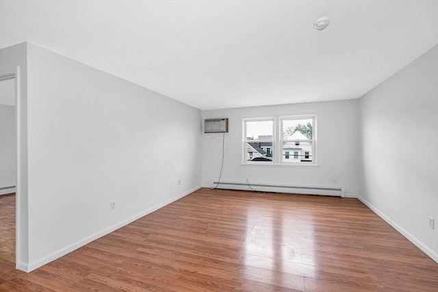 45 W 3rd St Unit 6, Lowell, MA 01850 - spare room with a baseboard heating unit, wood finished floors, and a wall mounted AC