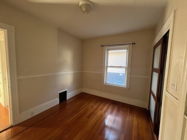 unfurnished room with dark hardwood / wood-style flooring