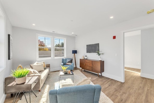 living area with visible vents, wood finished floors, baseboards, and recessed lighting
