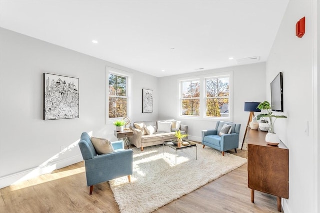 living room with light wood finished floors, baseboards, and recessed lighting