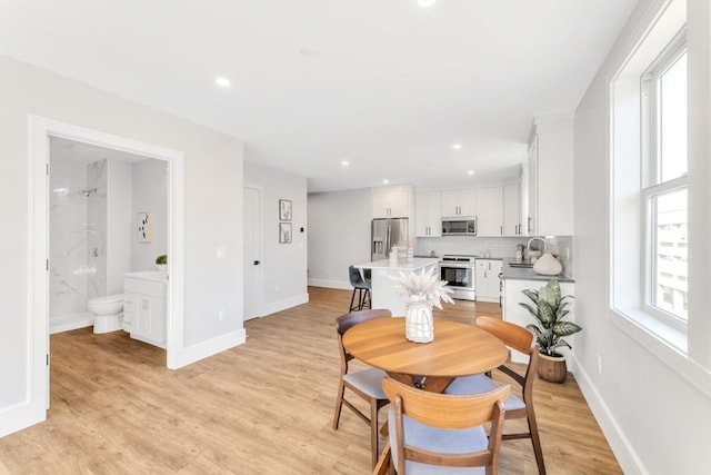 dining space with light wood-style flooring, baseboards, and recessed lighting