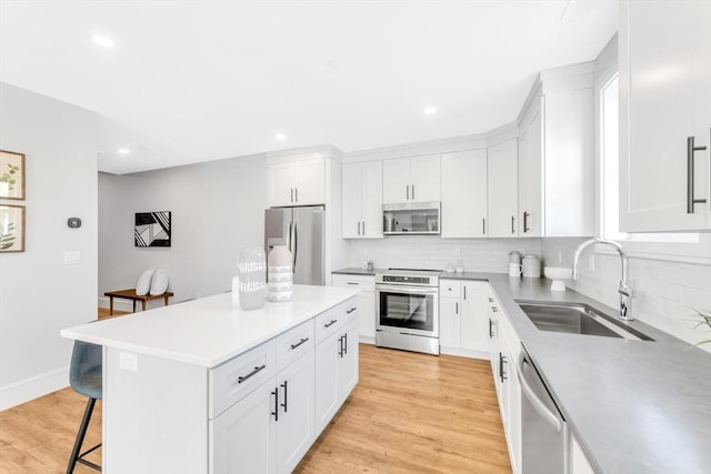 kitchen featuring a breakfast bar, stainless steel appliances, tasteful backsplash, and a sink