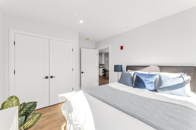 bedroom featuring a closet, light wood-type flooring, and recessed lighting