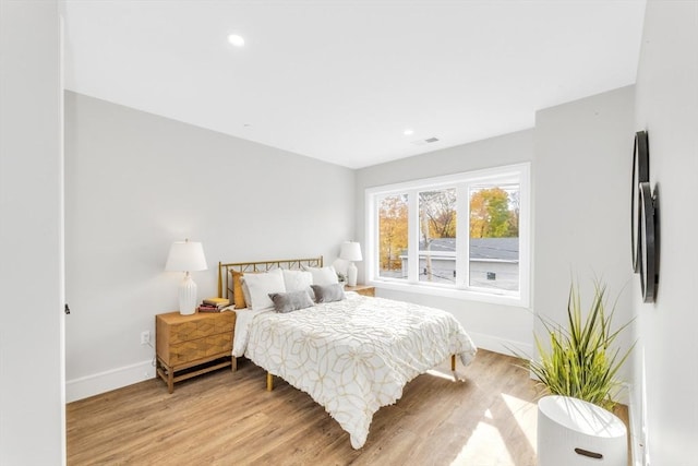 bedroom with light wood finished floors, baseboards, visible vents, and recessed lighting