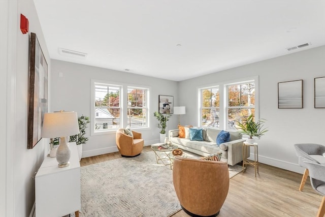 sitting room with light wood finished floors, visible vents, and plenty of natural light