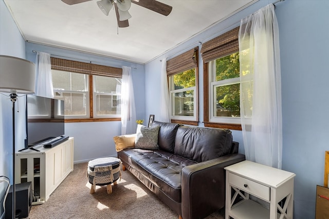 living room featuring light carpet, ceiling fan, and crown molding