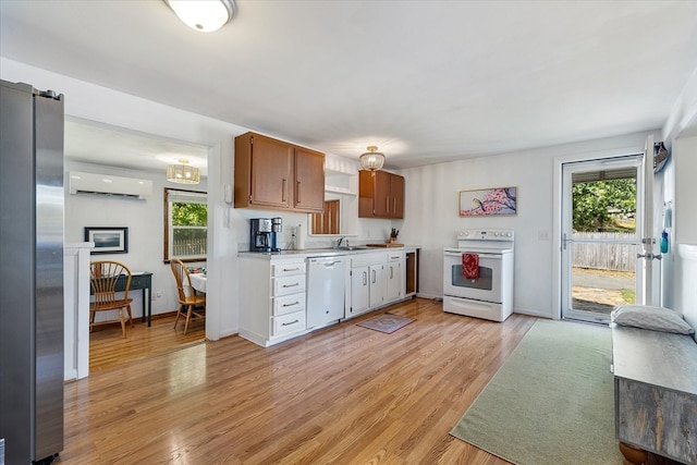 kitchen with light hardwood / wood-style floors, white appliances, beverage cooler, sink, and a wall mounted AC