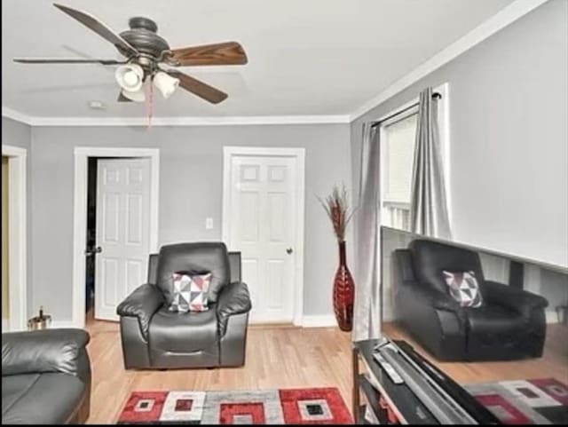 living room with light wood-type flooring, baseboards, ornamental molding, and a ceiling fan