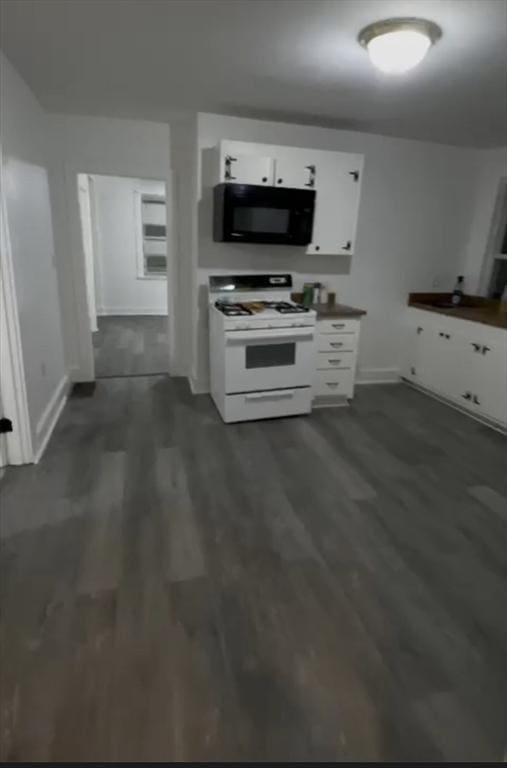 kitchen with black microwave, dark wood-style flooring, white cabinets, and white range with gas stovetop