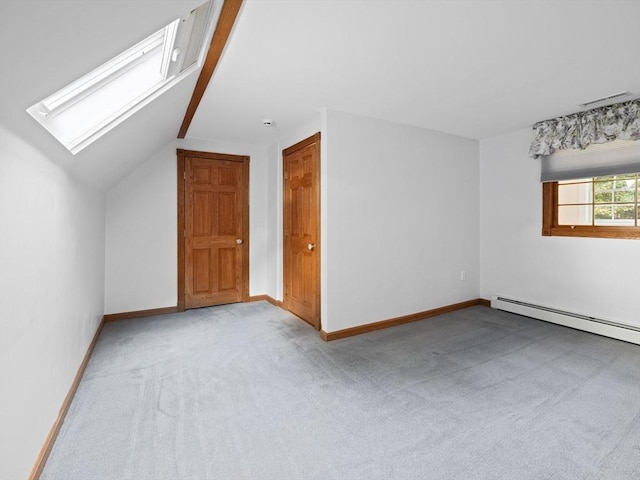 bonus room featuring vaulted ceiling with skylight, light colored carpet, and baseboard heating