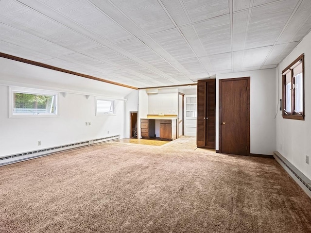 unfurnished living room featuring carpet floors and baseboard heating