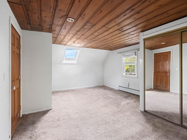 additional living space featuring baseboard heating, wood ceiling, plenty of natural light, and vaulted ceiling with skylight