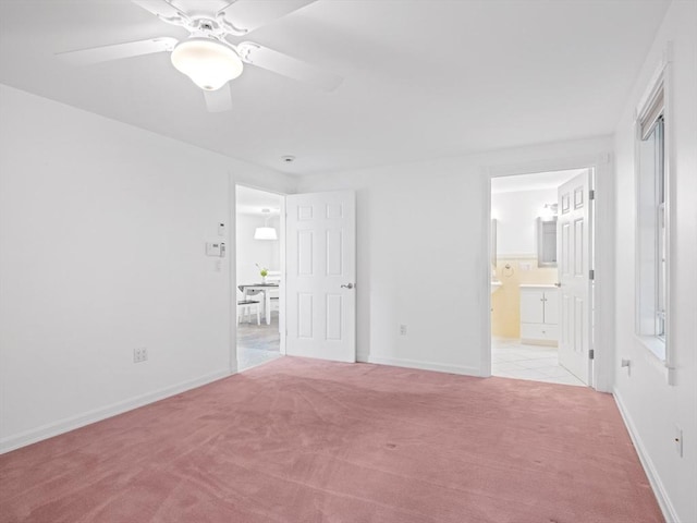 unfurnished bedroom featuring light carpet, ceiling fan, and connected bathroom