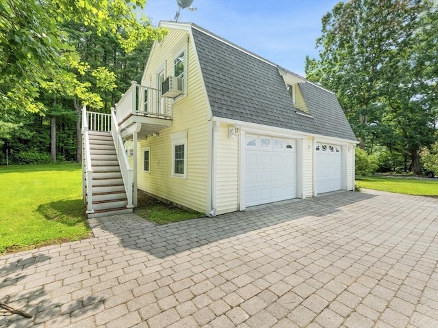 view of home's exterior featuring a garage, cooling unit, and a yard