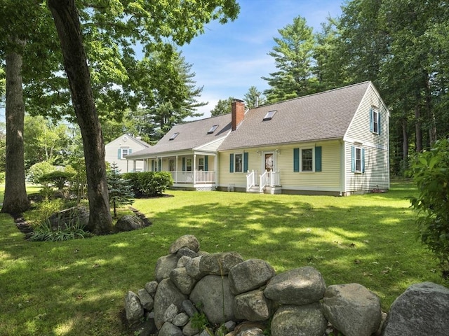 rear view of house featuring a yard