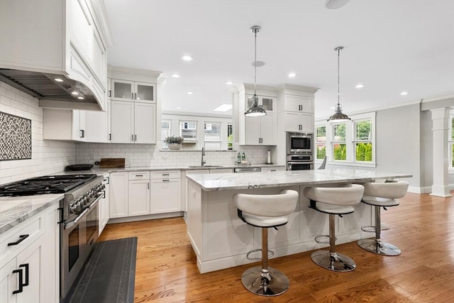 1 Apollo Cir, Lexington, MA 02421 - kitchen with stainless steel appliances, backsplash, custom range hood, a center island, and recessed lighting