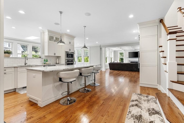 1 Apollo Cir, Lexington, MA 02421 - kitchen featuring stainless steel appliances, a center island, white cabinetry, light wood finished floors, and recessed lighting