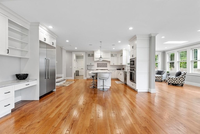 1 Apollo Cir, Lexington, MA 02421 - kitchen featuring appliances with stainless steel finishes, a kitchen bar, light countertops, light wood-style floors, and white cabinets